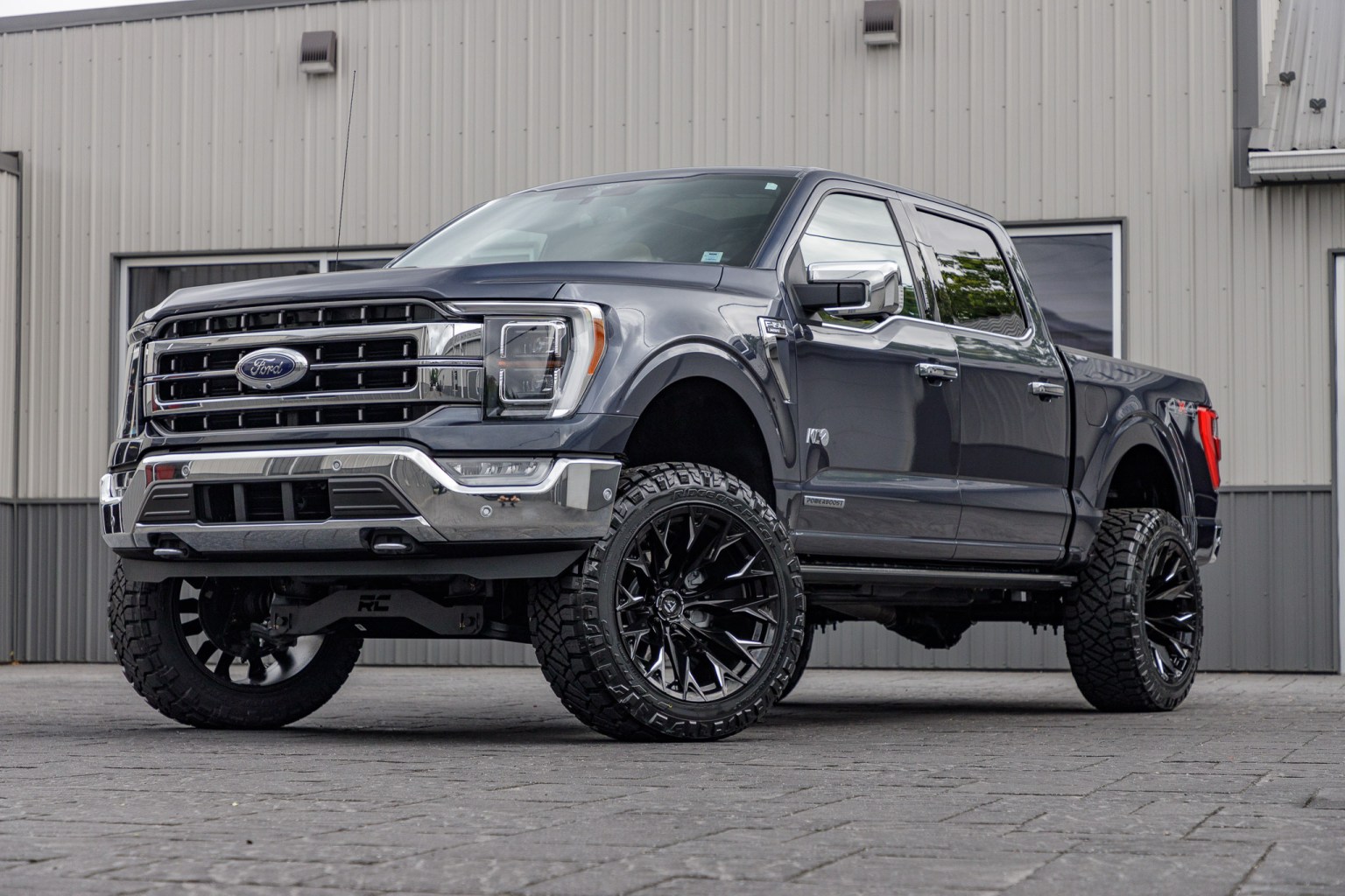 Lifted Ford F-150 with black wheels outside the Krietz workshop